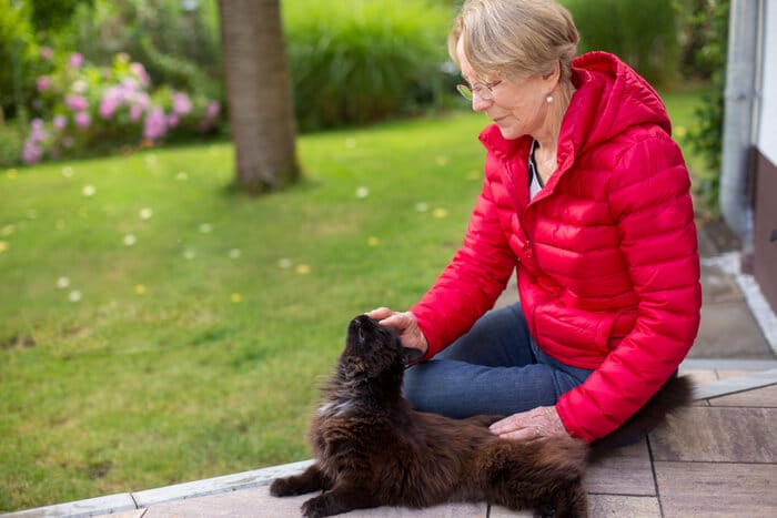 Une personne cherchant à l'extérieur avec une expression inquiète, probablement à la recherche d'un chat perdu.