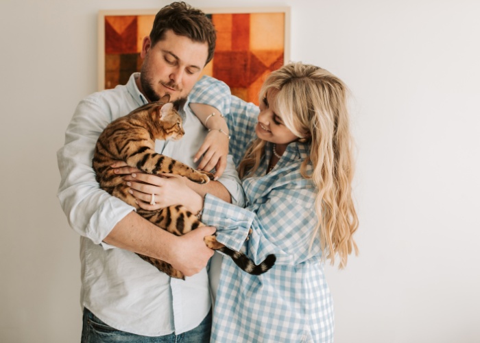 Charmante photo mettant en vedette un joli couple partageant un moment délicieux avec leur chat, illustrant la joie et l'amour que les animaux de compagnie peuvent apporter aux relations.