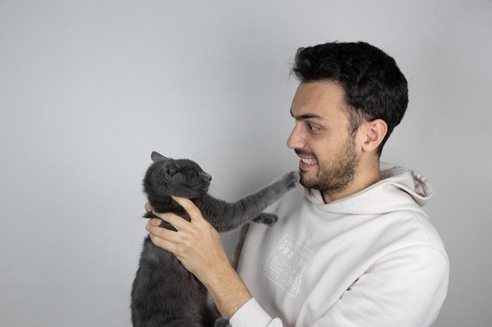 Une image représentant un homme interagissant avec un chat.