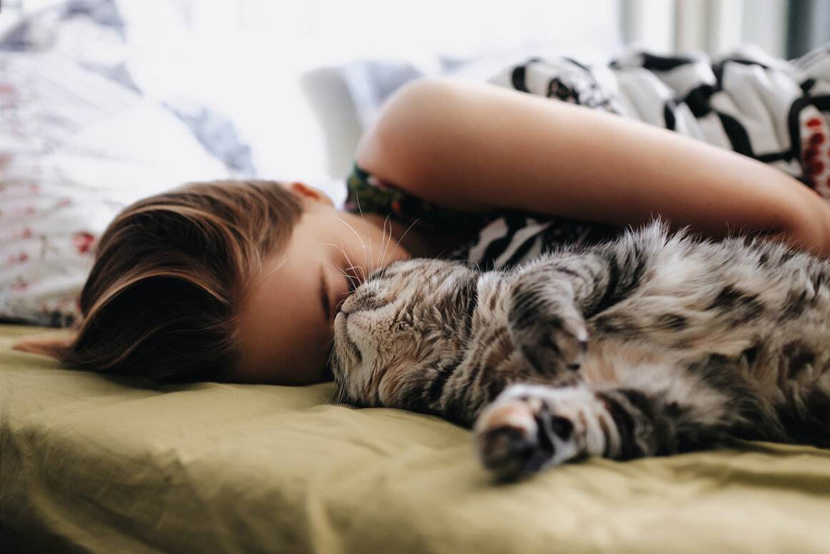 Une femme noue des liens avec un chat.