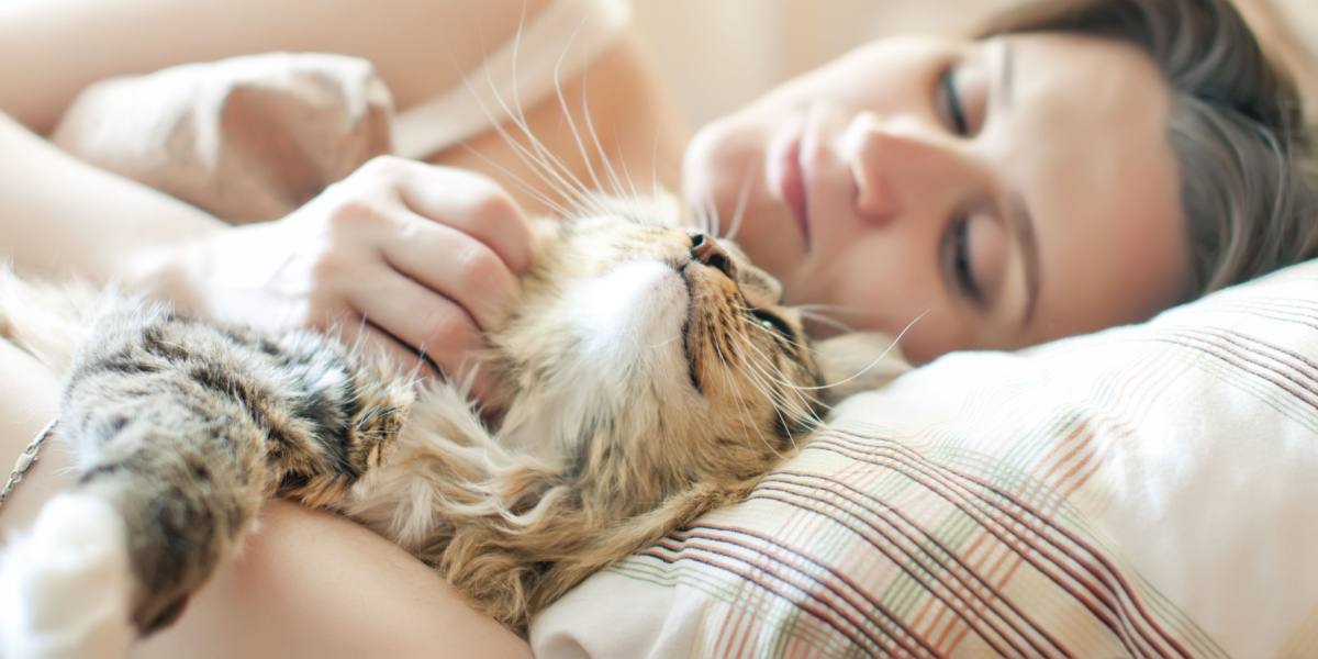 femme dormant avec un chat au lit