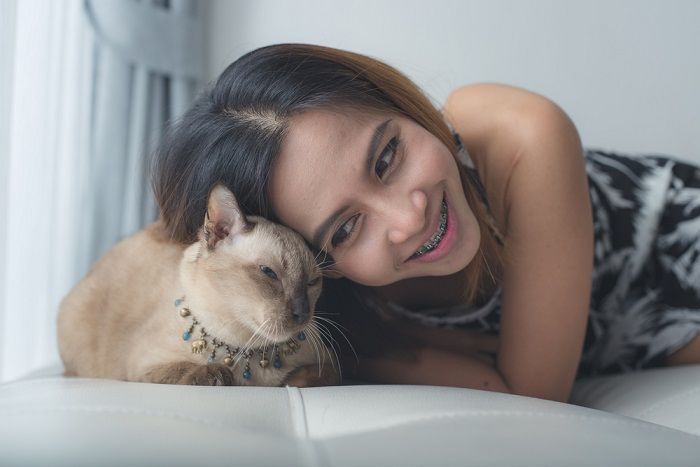 femme et chat allongés sur un canapé