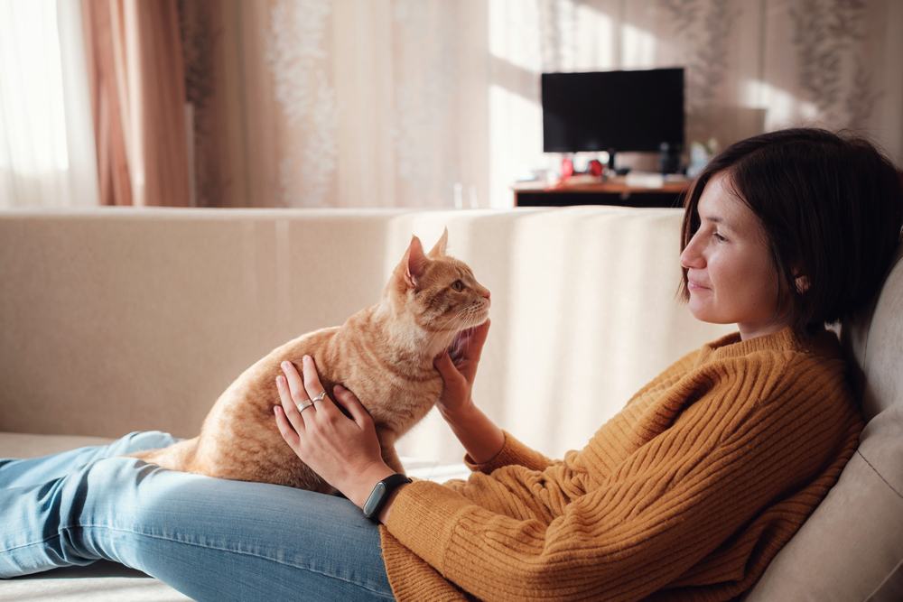 femme se reposant avec son animal de compagnie sur le canapé