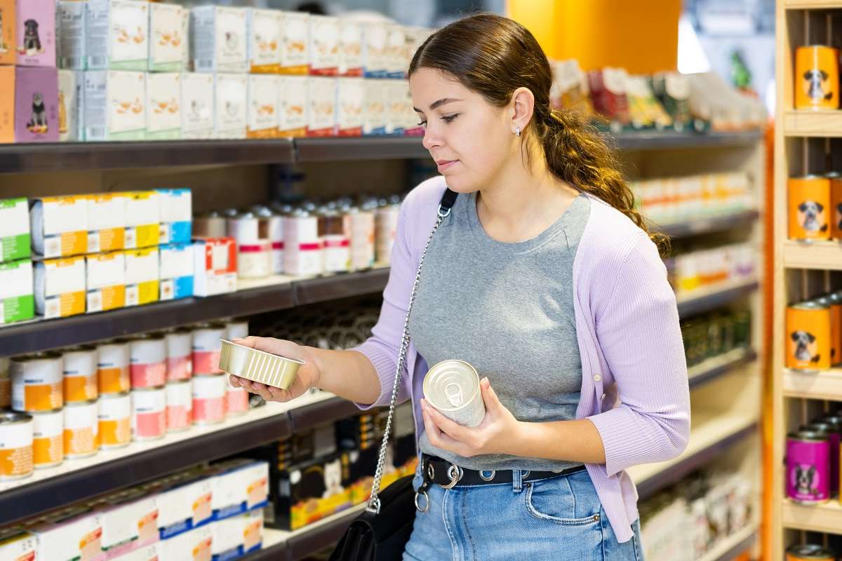 Une femme fait ses courses dans le rayon des aliments pour animaux